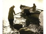 On the northern shore of the Lake of Galilee fishermen are bringing in their morning catch. This beach is near Tabghah, supposed site of Bethsaida. An early photograph.